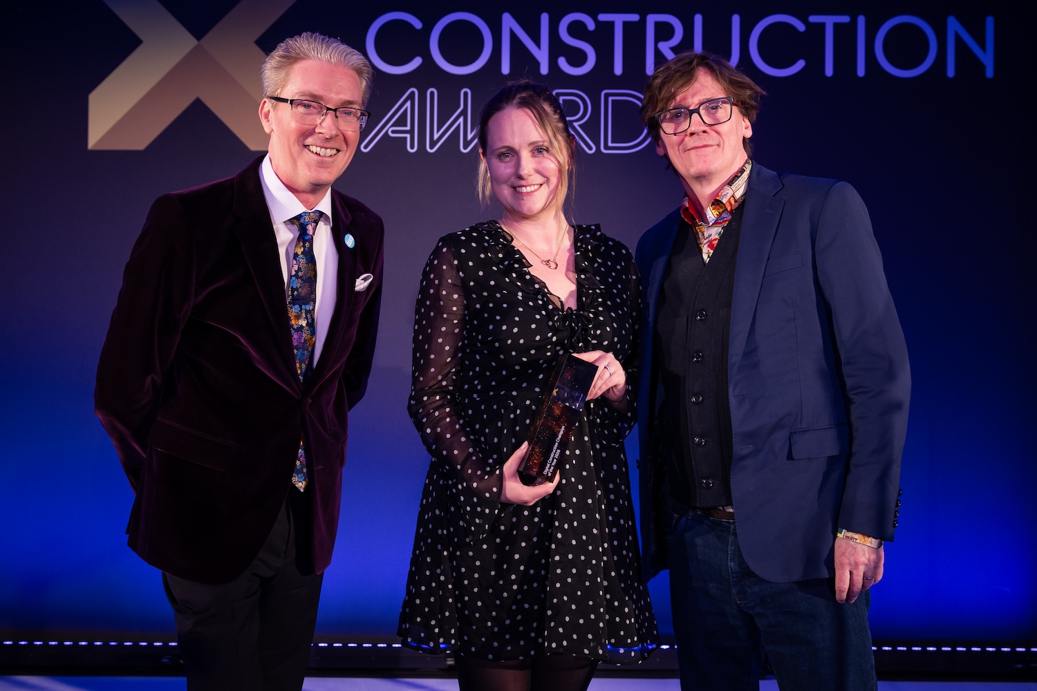 Dr Melanie Robinson received the trophy on behalf of Dr Anne Kemp OBE from Ed Byrne (right) and Justin Stanton of DC+ (left). Image: © 2026 - ASV Photography Ltd. www.ASVphotos.com